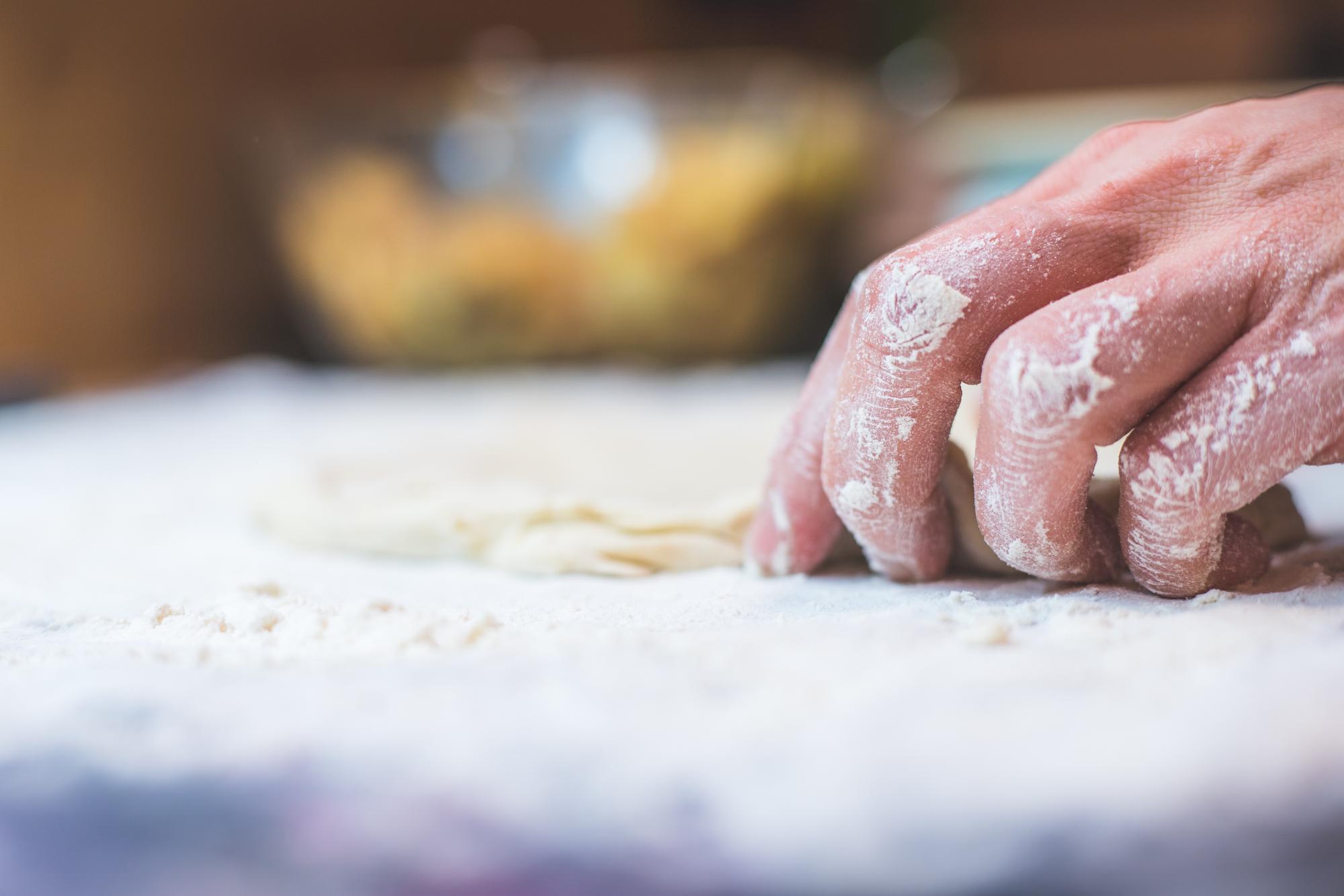 Large photo: hands kneading dough